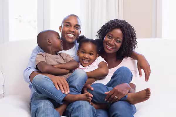 Família angolana sentada no sofá com os dois filhos