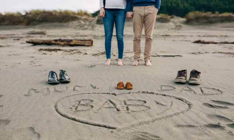 Couple attendant un enfant sur la plage
