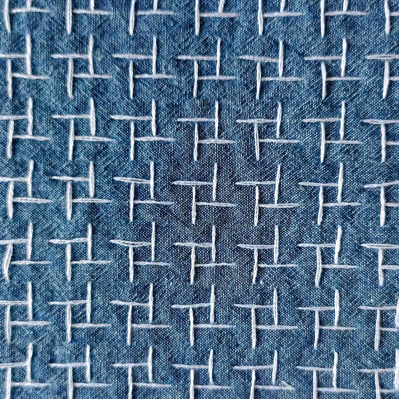 Close-up of an embroidered pattern sewn by hand in the studio