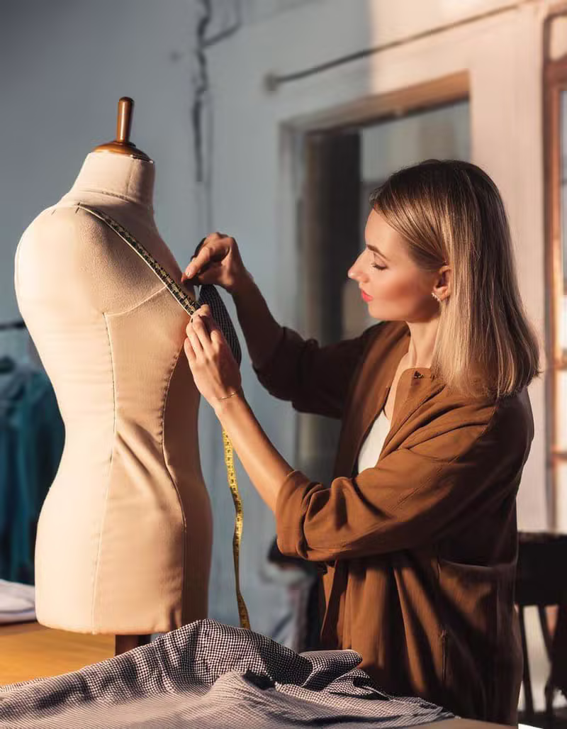 An OpalThread couturier taking measurements on a dress form in the studio
