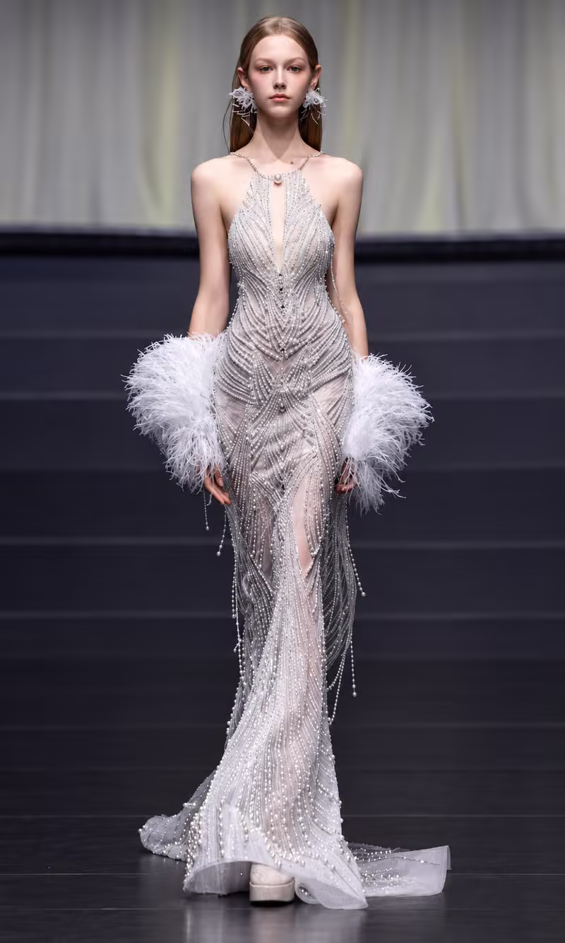 White pearl-beaded couture gown with soft feather sleeves