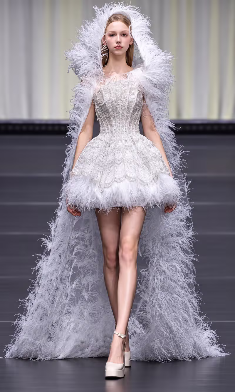 White feathered couture gown with a dramatic hooded feather cape