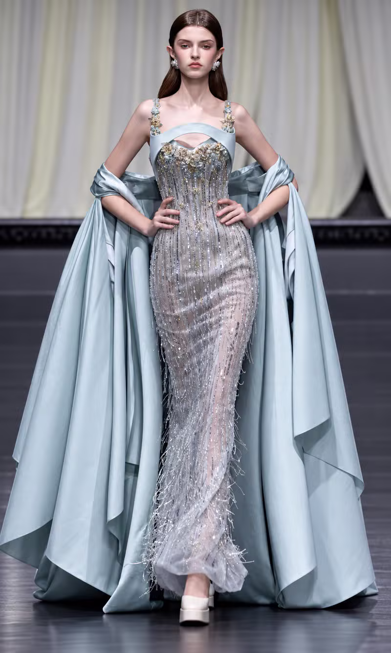 Pale seafoam couture gown with a beaded bodice and draped satin cape