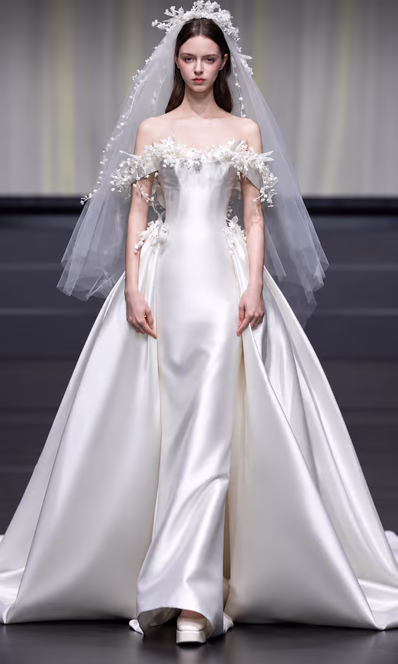 Ivory off-shoulder satin bridal gown with a floral applique veil