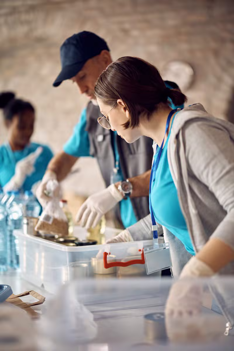 Voluntarios preparando cajas de donaciones para una comunidad