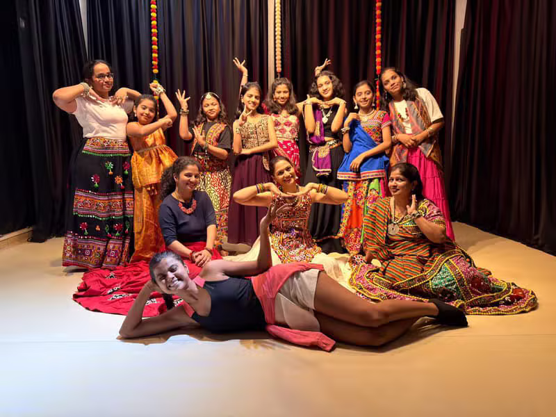 Dancers in colourful Navratri chaniya choli posing together on stage