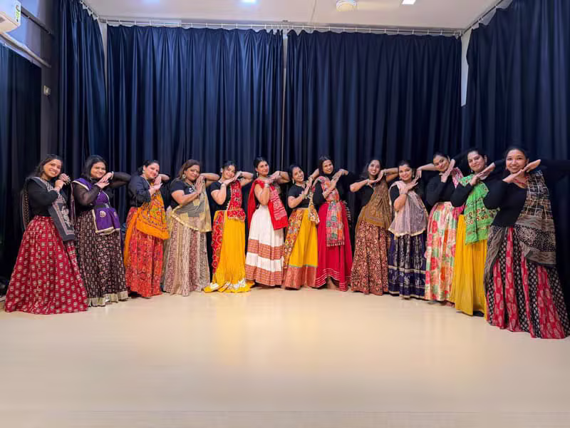 Line of dancers in traditional outfits holding a semi-classical pose