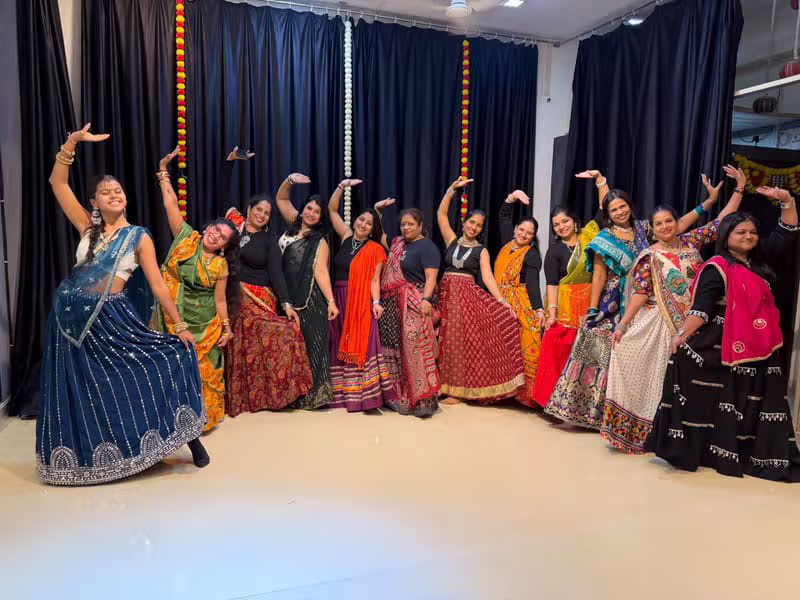 Group of dancers in colourful outfits striking a Bollywood pose
