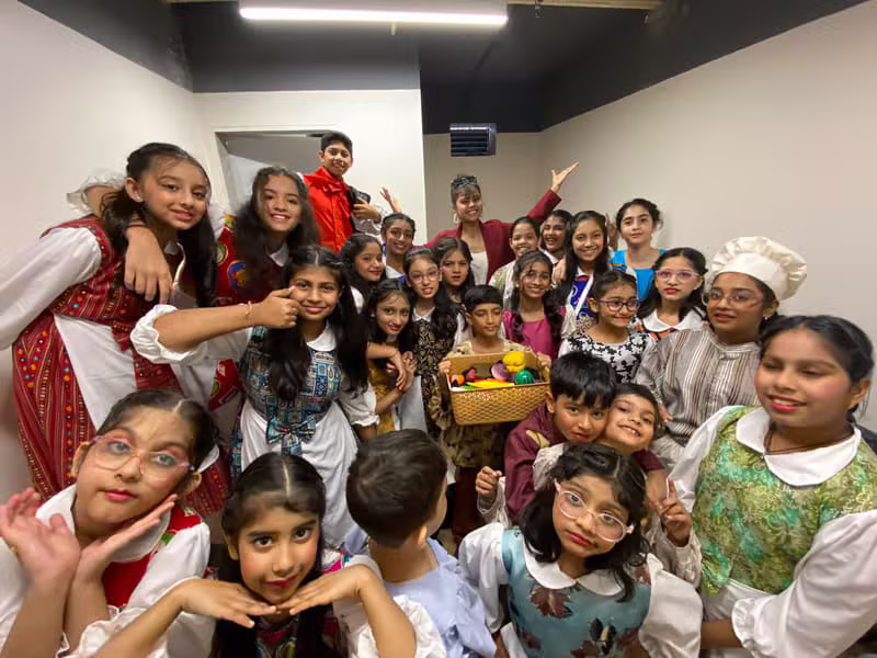 Children in fancy-dress costumes posing backstage