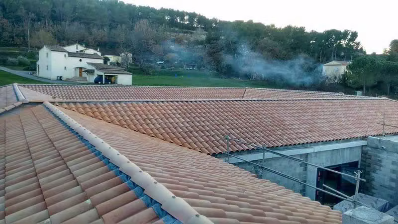 Charpentier posant une charpente en bois massif