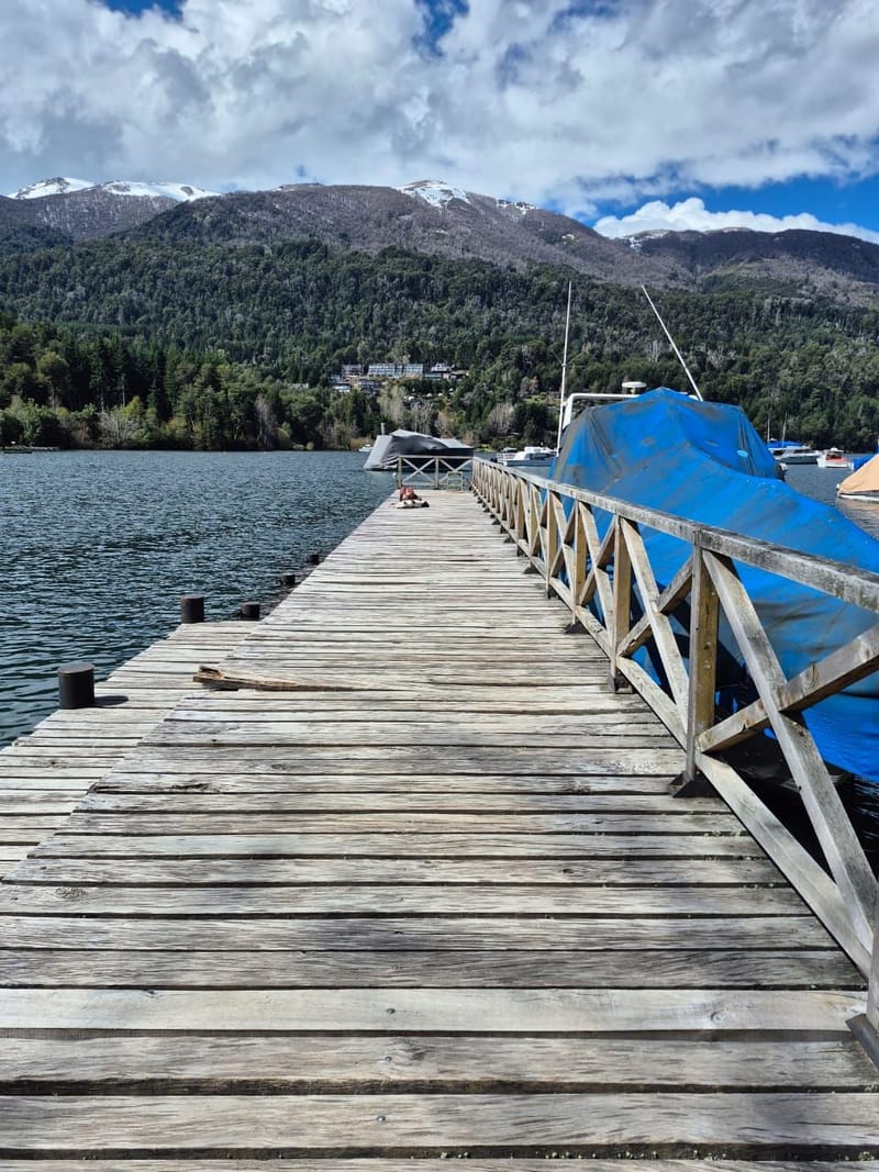 Embarcación de CHARLI 1 navegando el lago Nahuel Huapi entre bosques y montañas