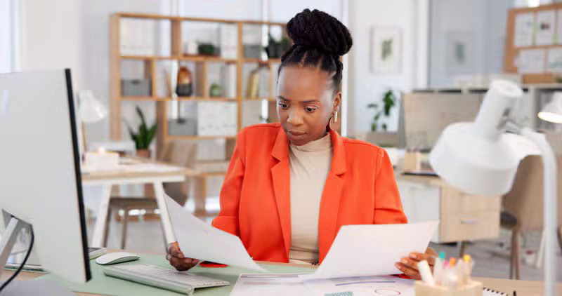 Black accountants reviewing financial statements in a modern office