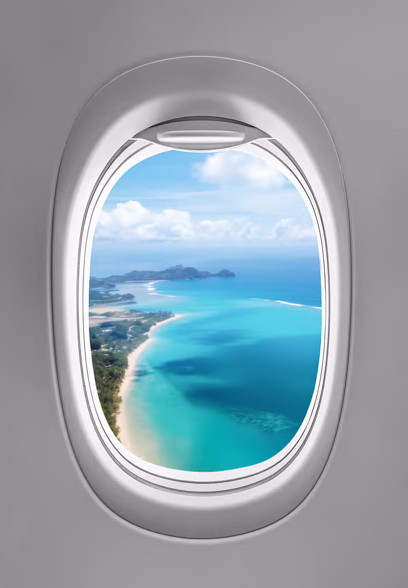 Airplane window view of a sunlit coastline