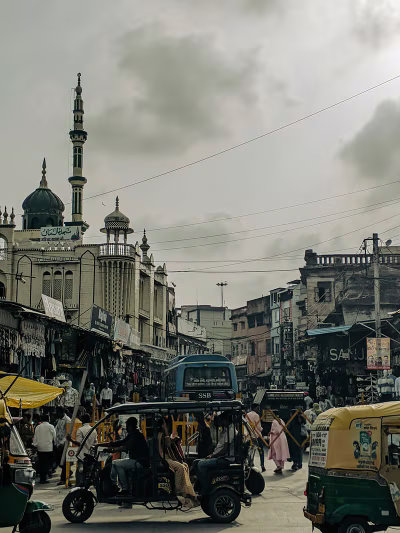 A busy commercial street in an Indian city lined with local shops and businesses