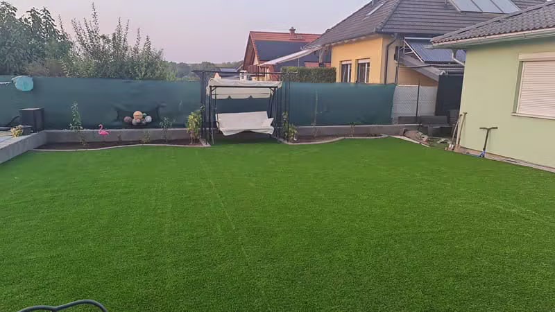 Umělý trávník v zahradě s houpačkou v podvečeru
