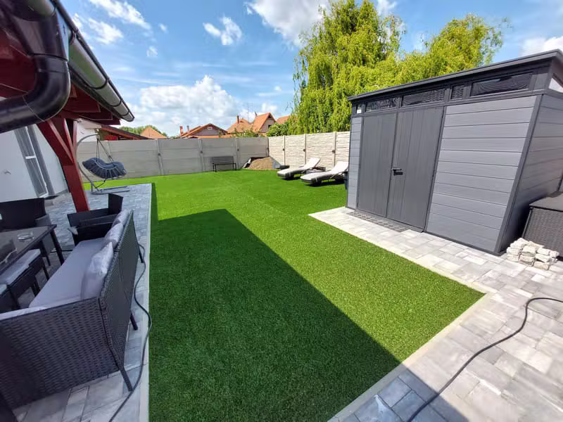 Moderní zahrada s umělým trávníkem, domkem a lehátky