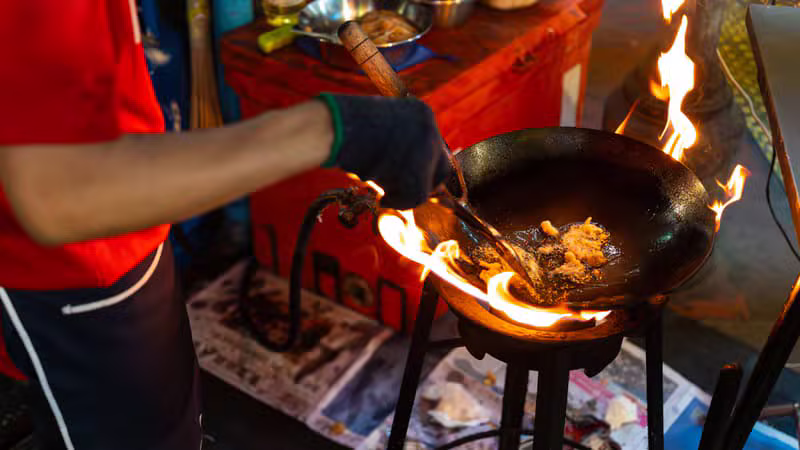 Thai market vendor preparing and packing authentic food products in Bangkok