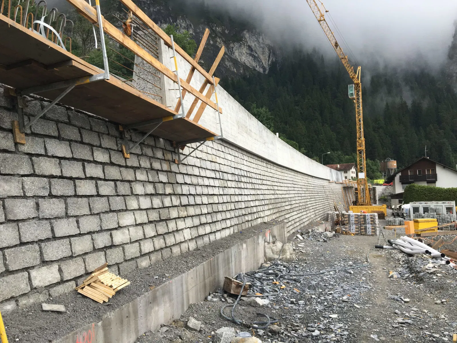 Neue steinverkleidete talseitige Schwergewichtsmauer