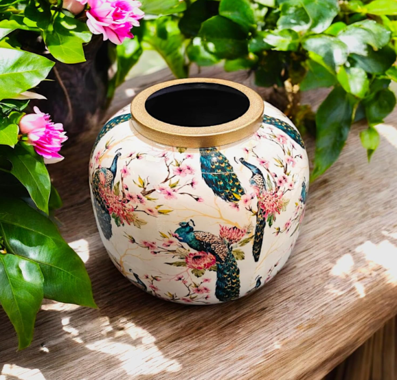 : “Decorative flower vase on wooden surface with green foliage background