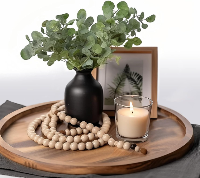 The tray styled with a candle, small vase, and a beaded garland, evoking a serene, spiritual ambiance