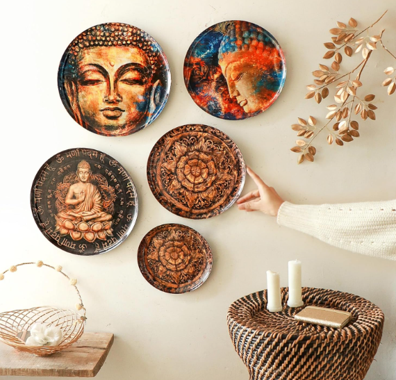 Handmade wall plates displayed above a wicker basket and leafy plant, showcasing a cozy, nature-inspired interior setup.