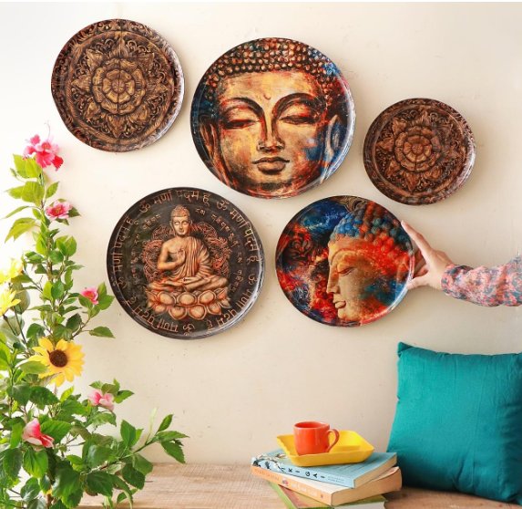 Decorative wall plates mounted above a small table and indoor plant, highlighting a vibrant and inviting home corner.