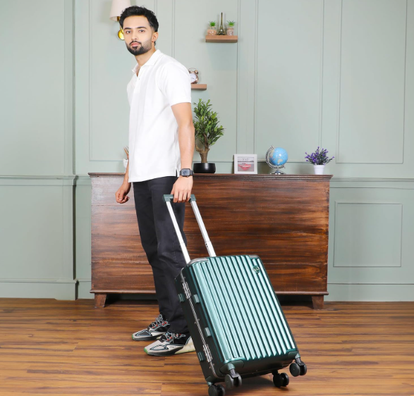 A person casually pulling a Stark suitcase across a wooden floor in a modern home setting, suggesting ease of use.
