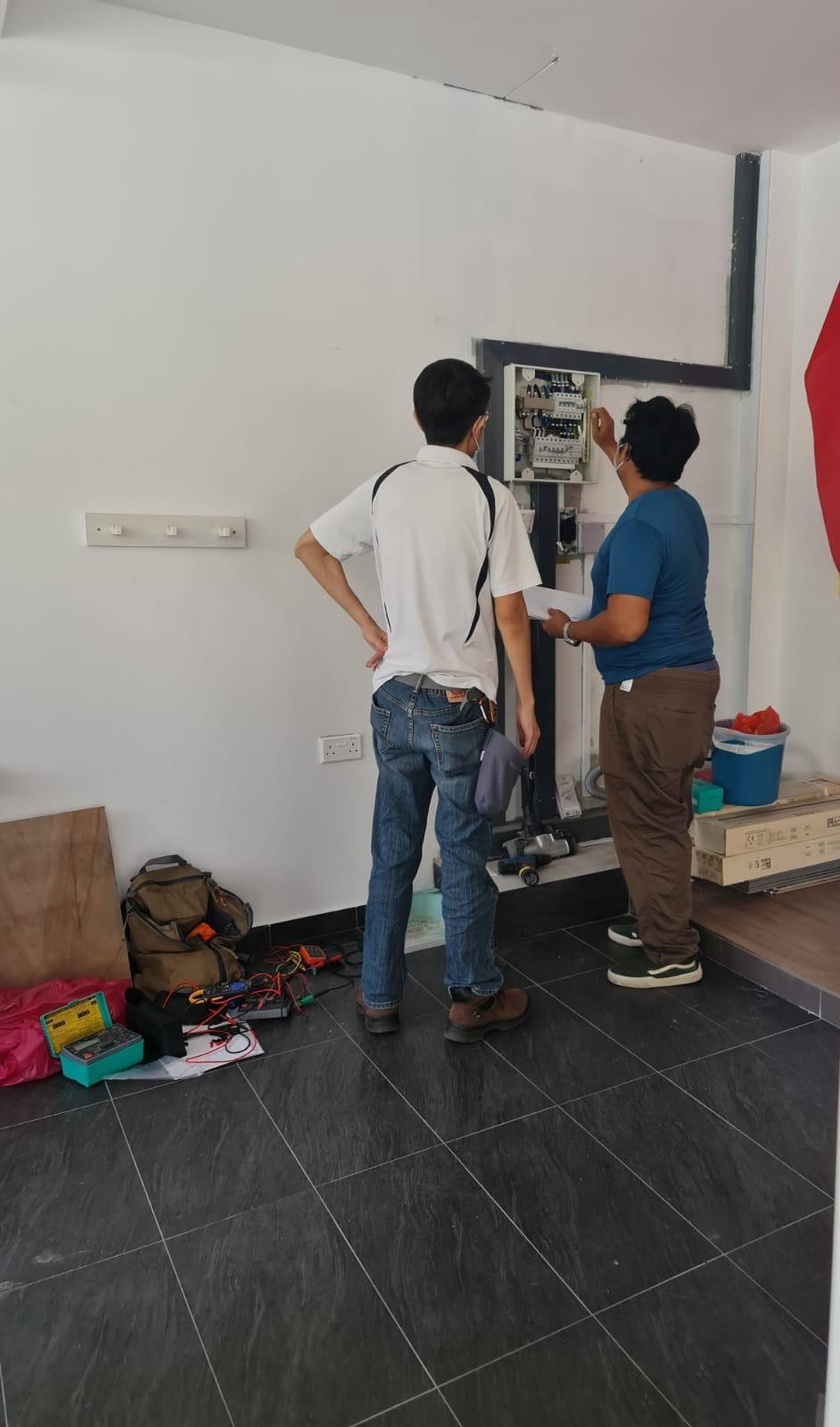 Licensed electrician in Singapore carrying out electrical inspection and testing at a distribution board