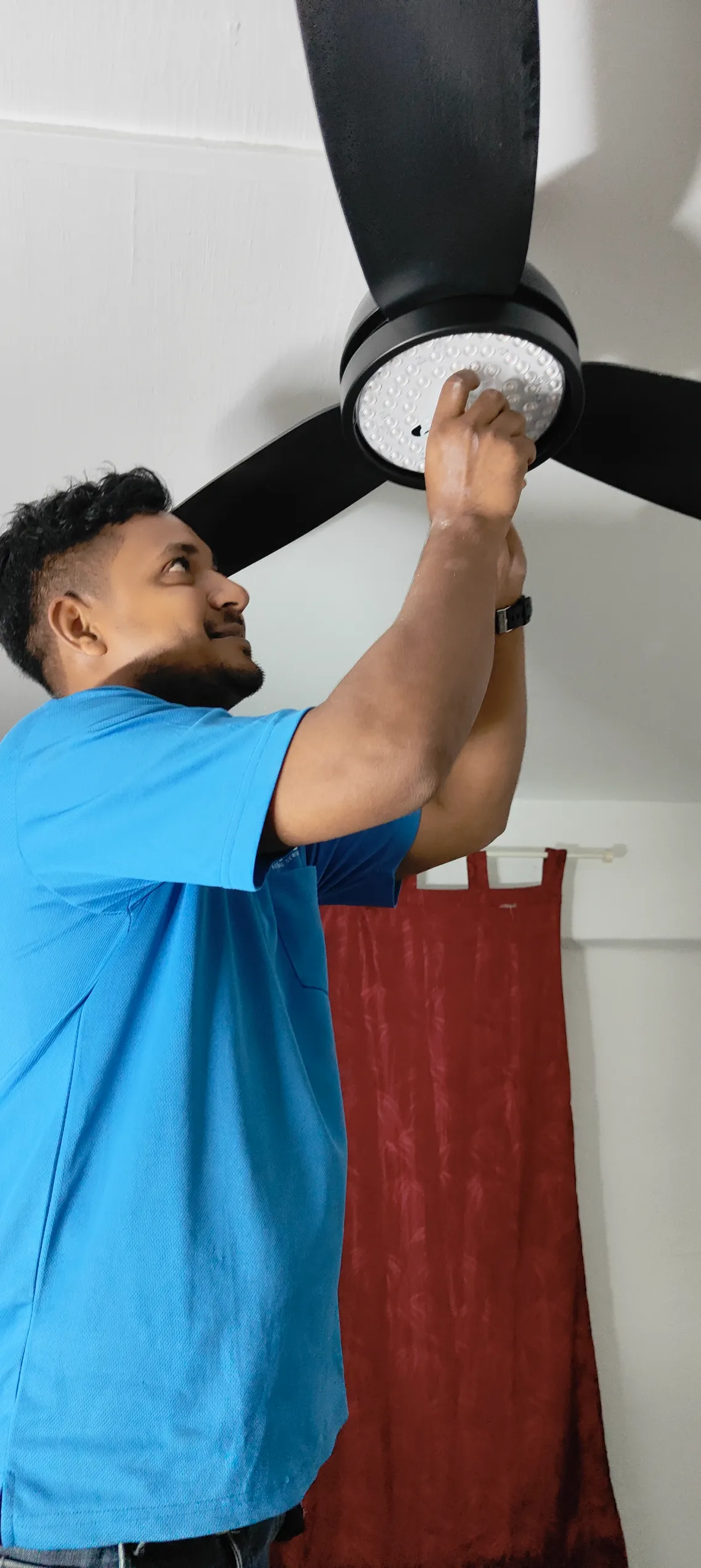 Lito Electrical technician installing ceiling fan in Singapore