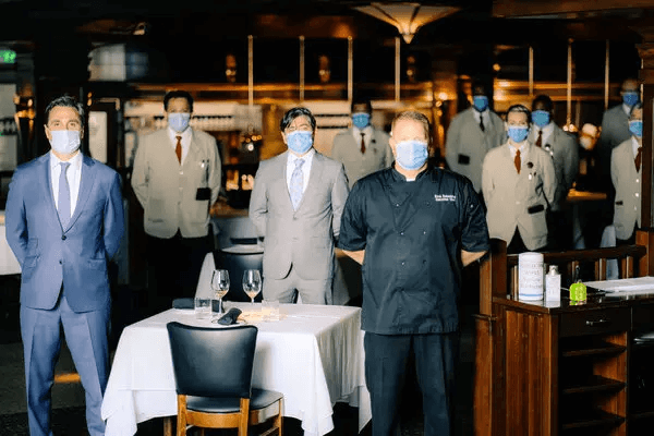 The staff at Chops Lobster Bar in the Buckhead neighborhood of Atlanta preparing for a shift, in the facial uniform of the moment.