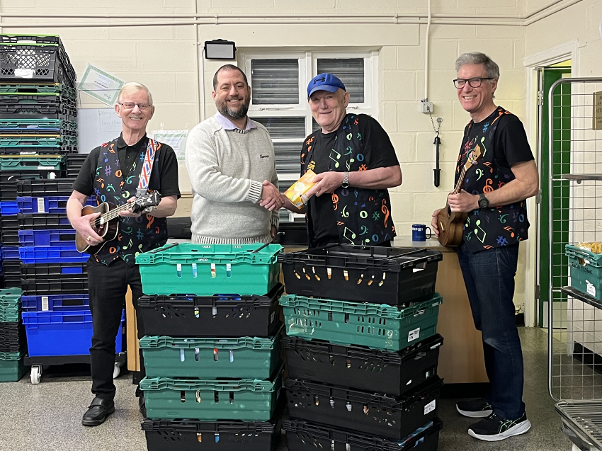 The D’Ukes of Halton Ukulele Band presenting £250 worth of food to the Runcorn Food Bank