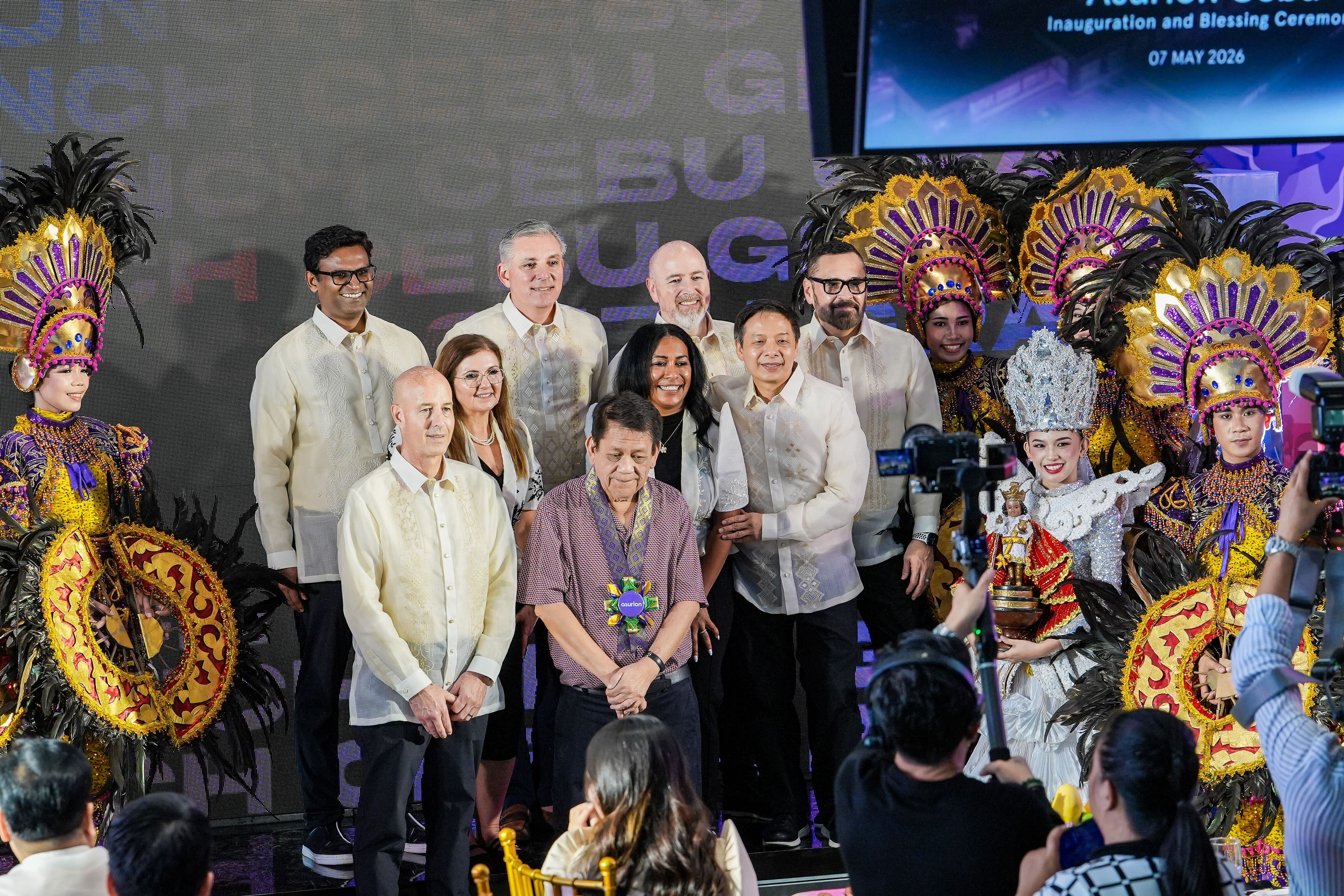 Asurion executives and Cebu officials pose during the inauguration and blessing ceremony of the Asurion Cebu site on May 7, 2026, alongside Sinulog performers in traditional Cebuano costumes