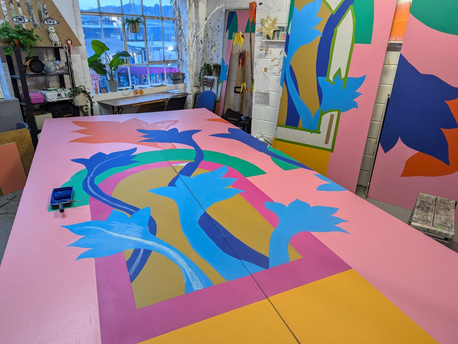 Photograph of a mural being painted in the artist's workshop