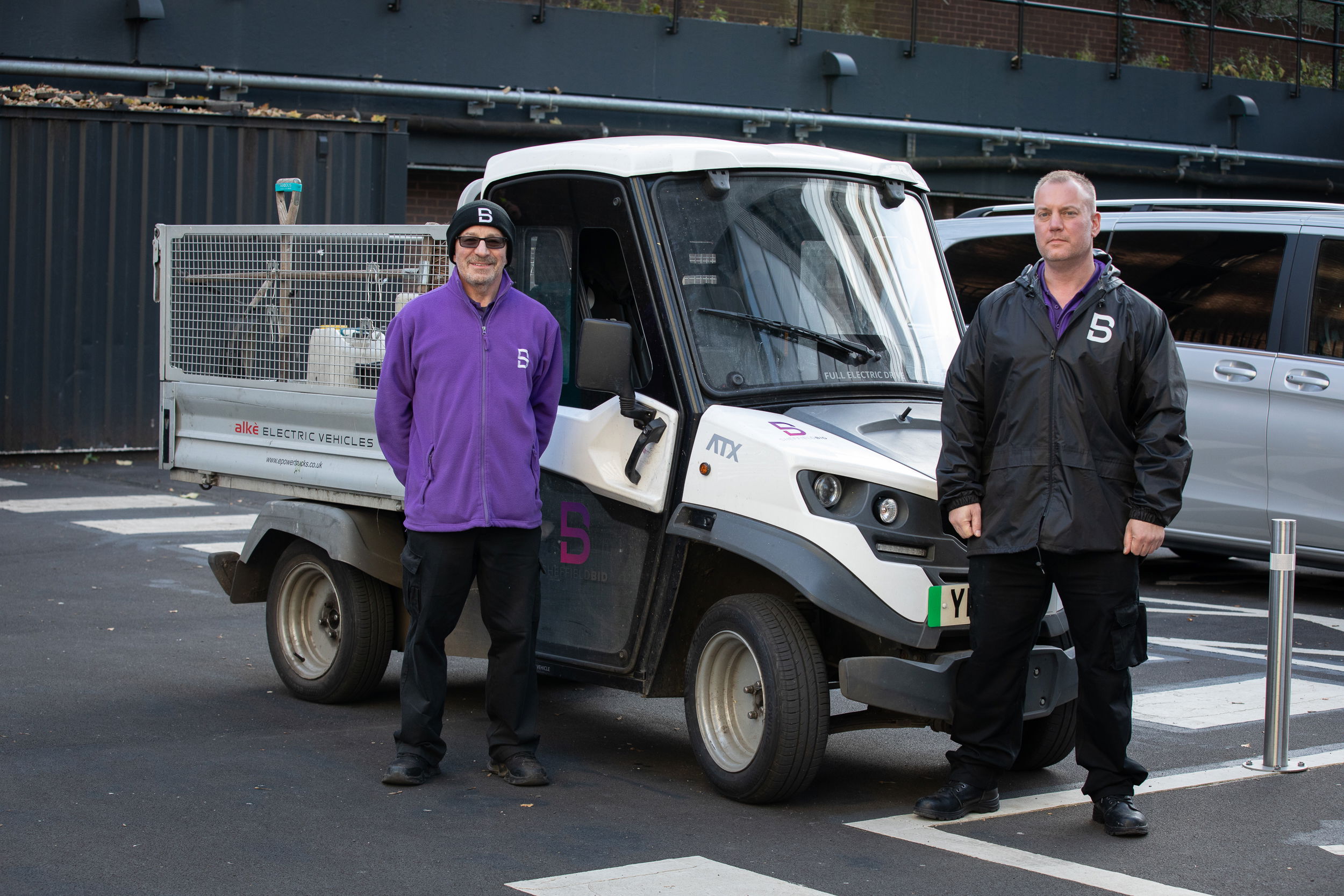 Two members of the Sheffield BID clean team alongside the BID's electric vehicle