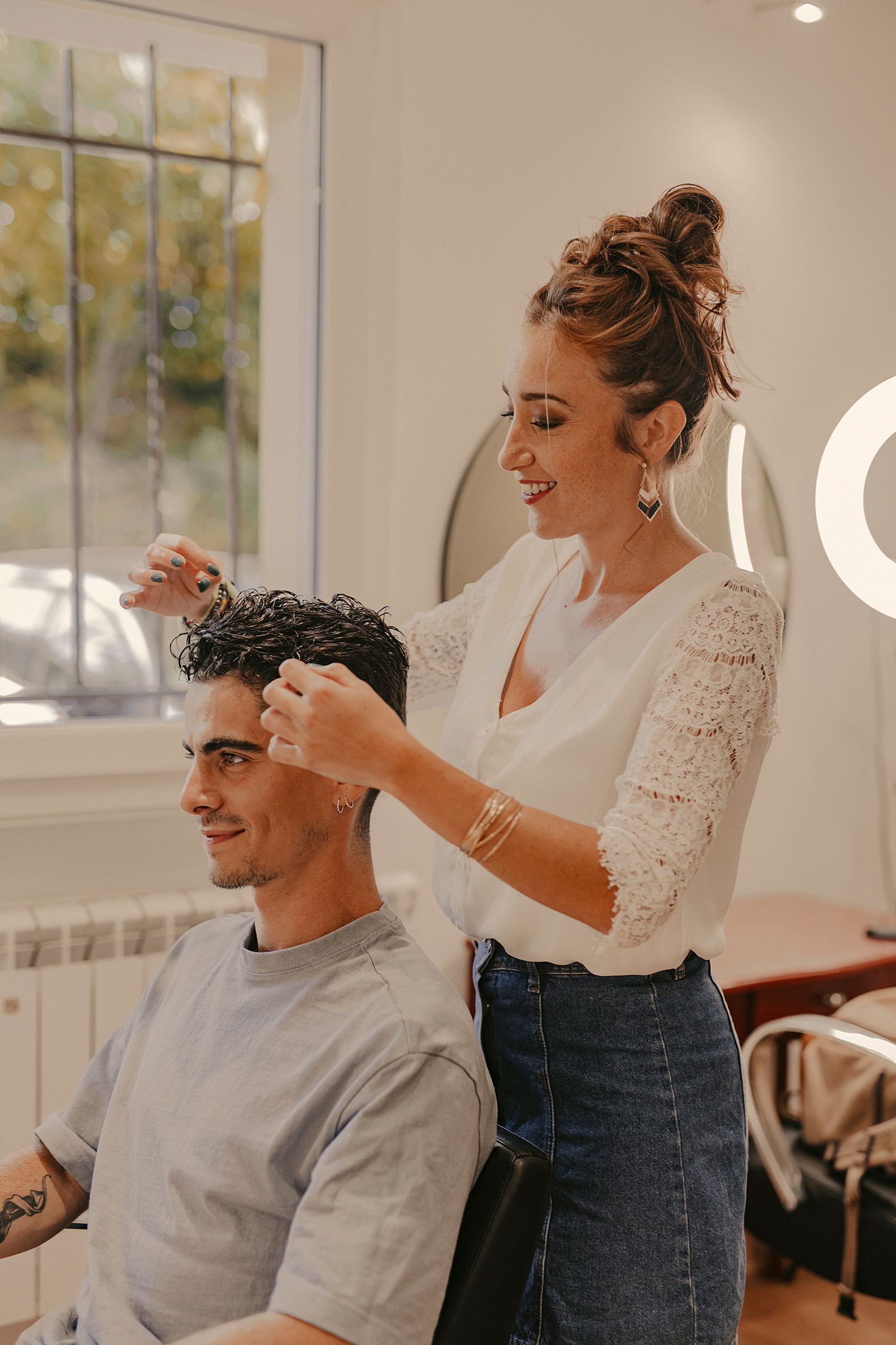 Anais Faure dans son salon de coiffure en train de réaliser une coupe homme