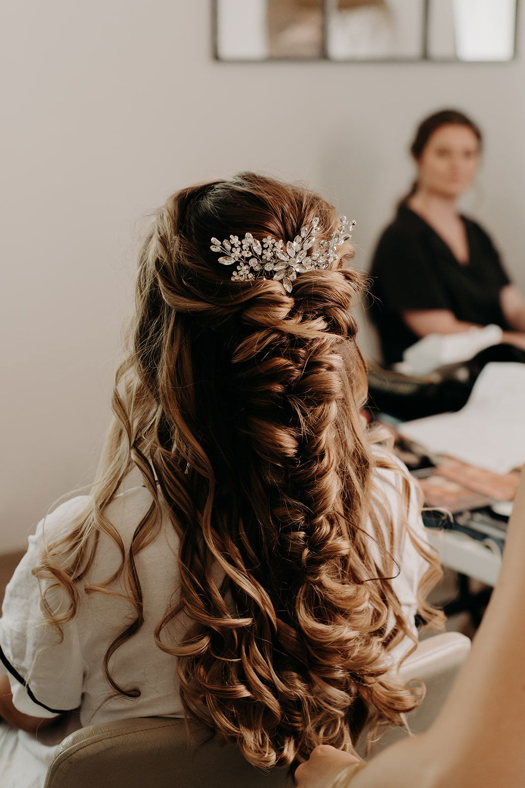 Mariée maquillage lumineux, cheveux longs et bouclés, tresse épis souple, peigne en strass fleurs