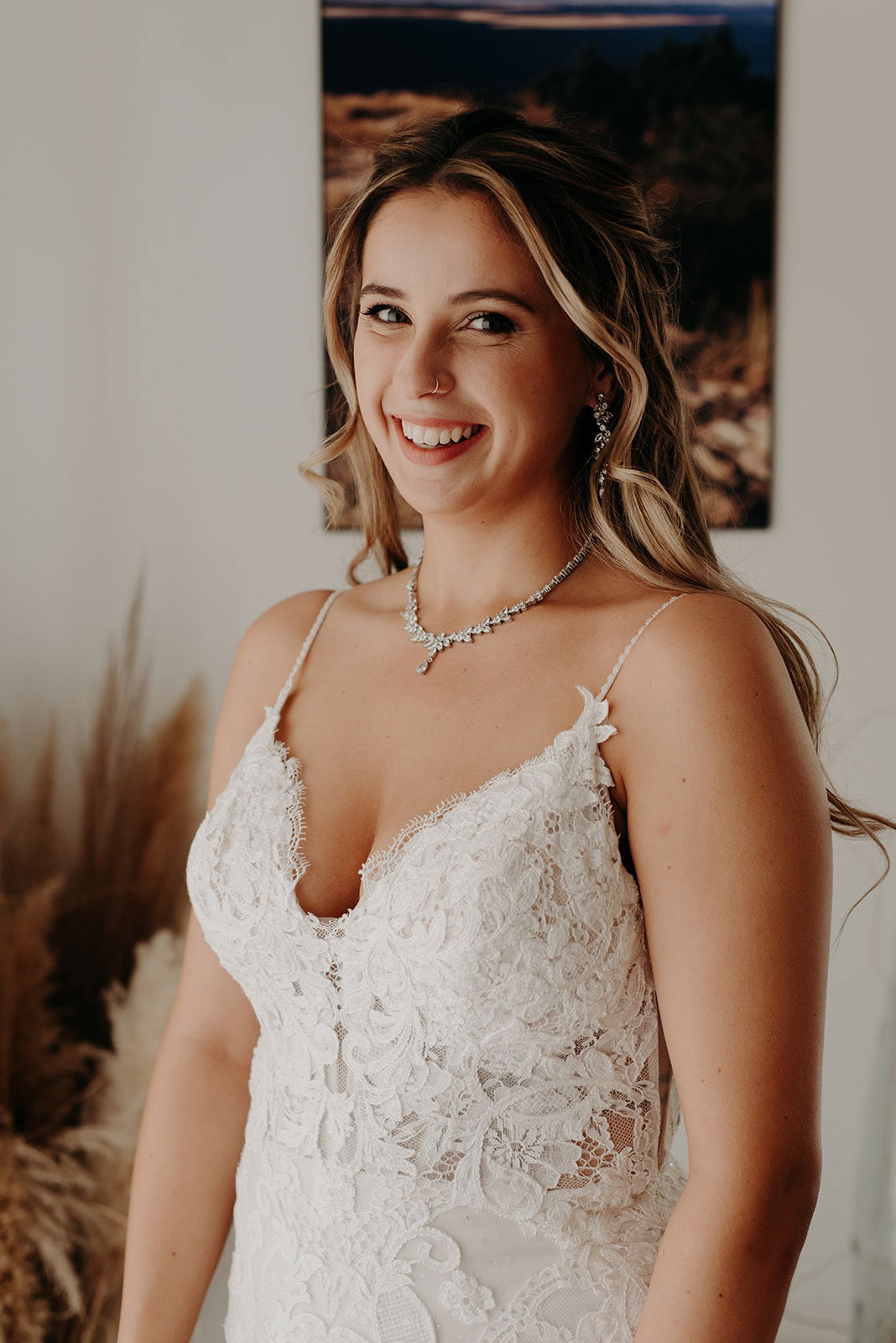 Mariée maquillage lumineux, cheveux longs et bouclés, tresse épis souple, peigne en strass fleurs