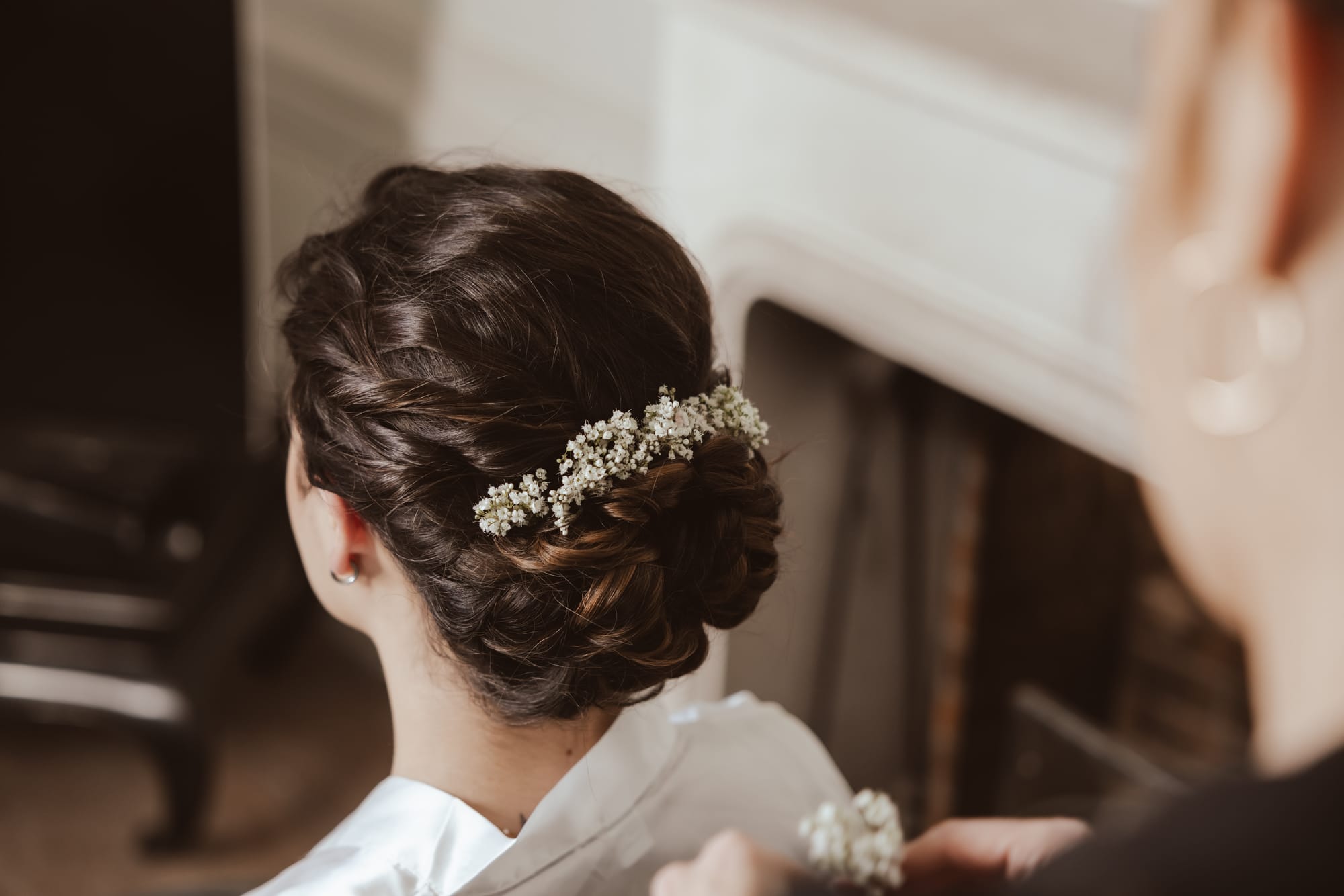Coiffure de mariage chignon bas avec torsades et fleurs gypsophile