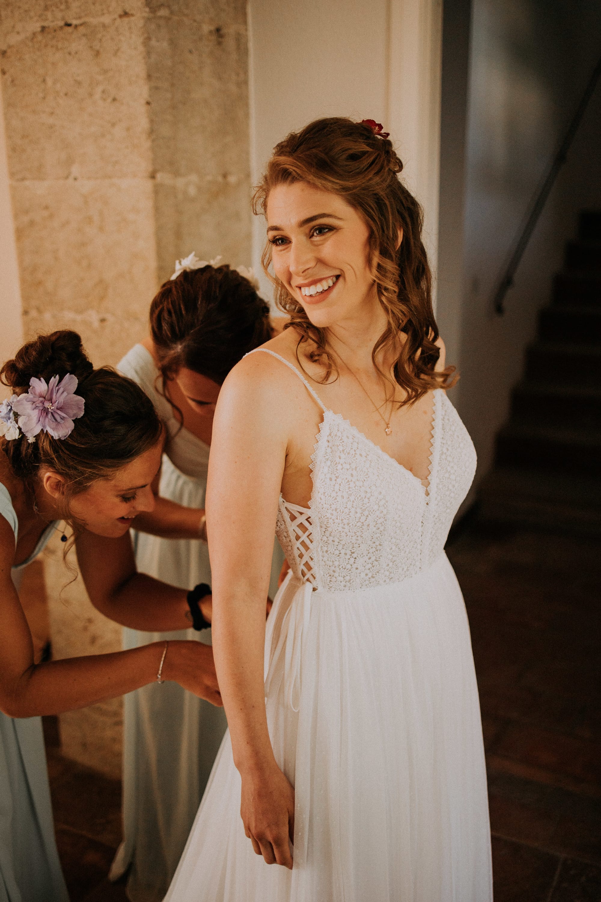 Mariée robe guipure à bretelles, coiffure cheveux longs et bouclés