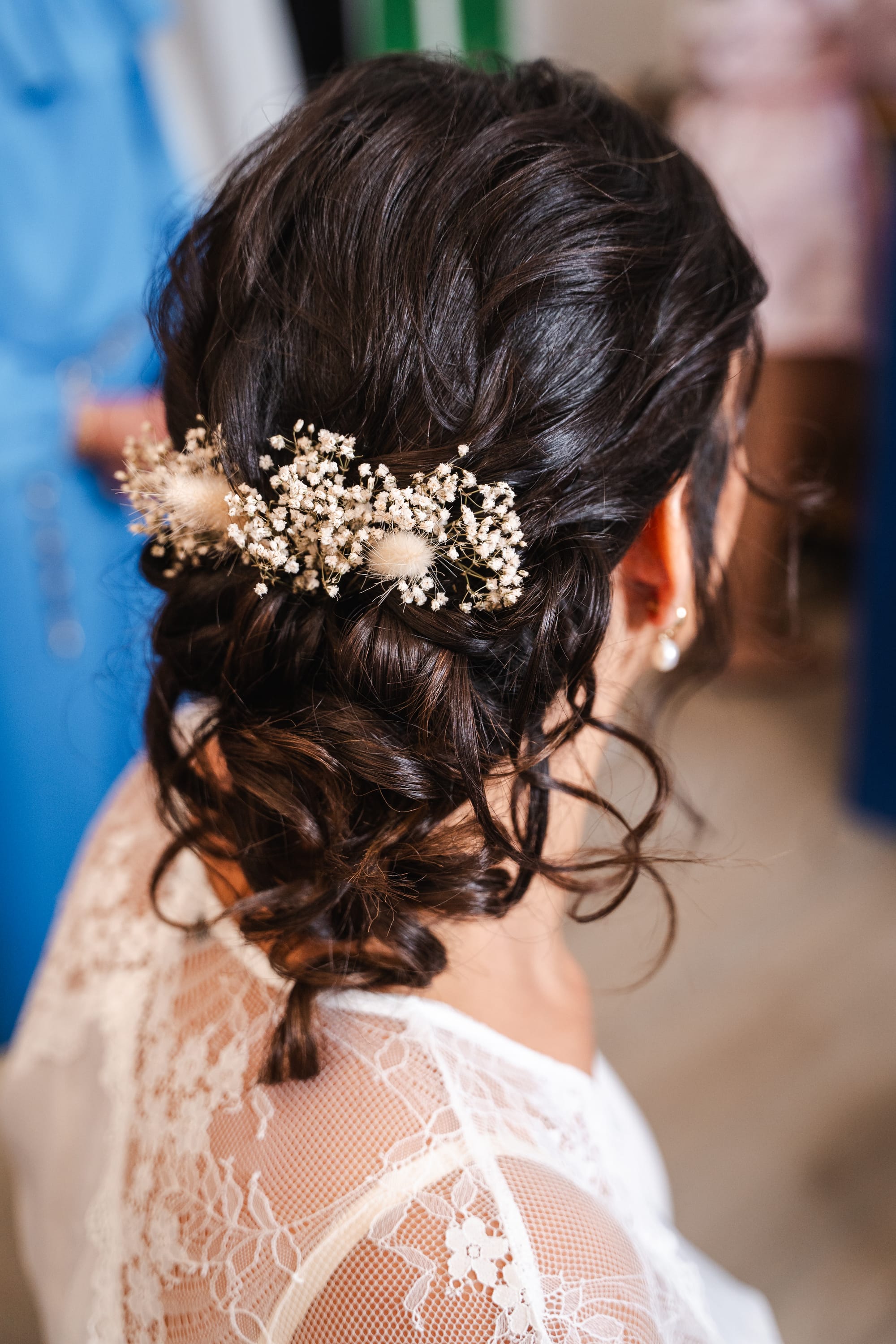 Chignon de mariée avec boucles souples, fleurs séchées et gypsophile