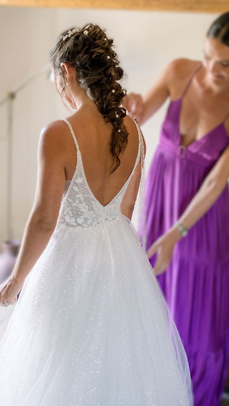Coiffure de mariée avec tresse longue floue, piquée de perles blanches