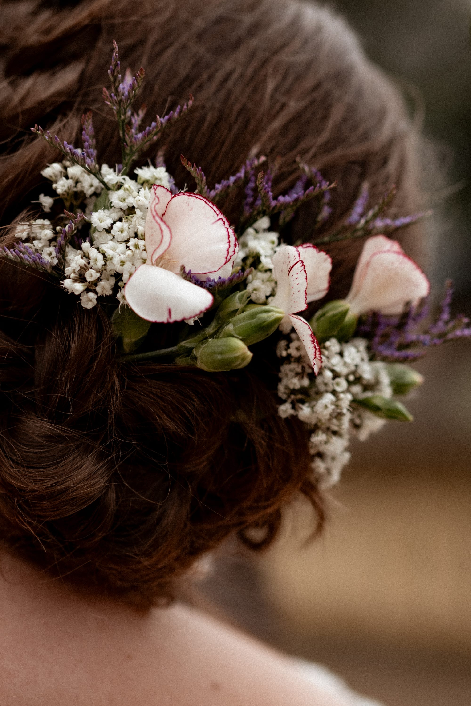 Coiffure de mariée avec fleurs naturelles, œillet, gypsophile, fleurs violettes
