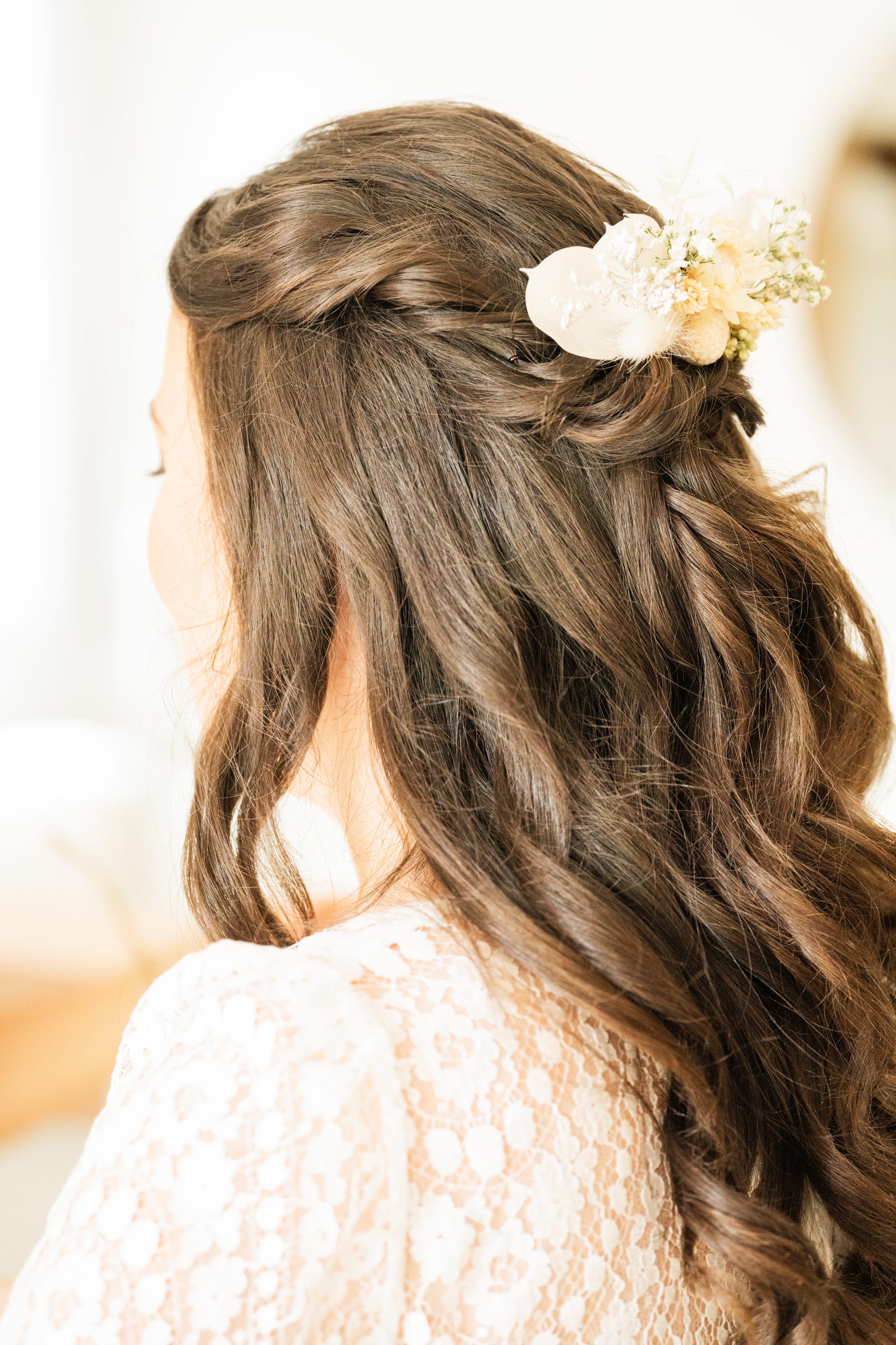 Coiffure de mariée avec torsade haute et fleur séchées blanches