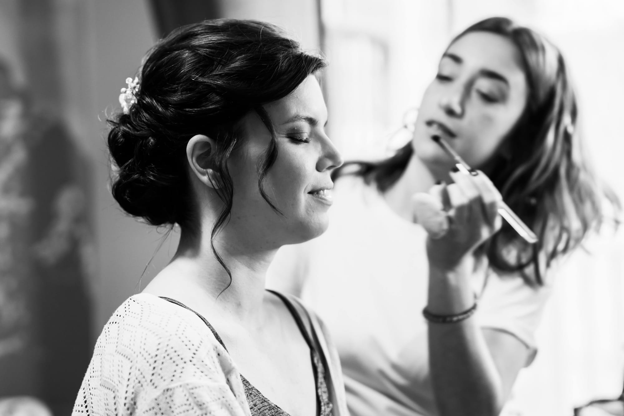 Cheveux brun foncé relevés en chignon élégant, maquillage naturel aux tons doux