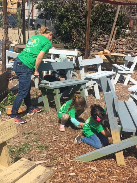 Rebecca Ochoa painting benches with daughters Isabella and Grace