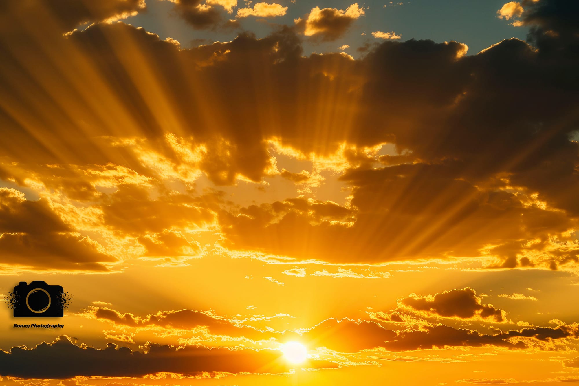 The setting sun peeking out from between the clouds