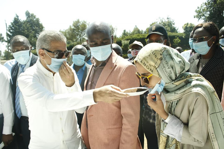 Iran's ambassador to Kenya Jafar Marmaki offers his daughter tea from Bomet as Governor Hillary Barchok looks on.