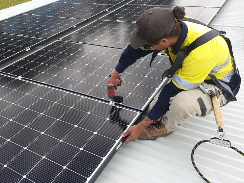 Worker installing rooftop solar panels