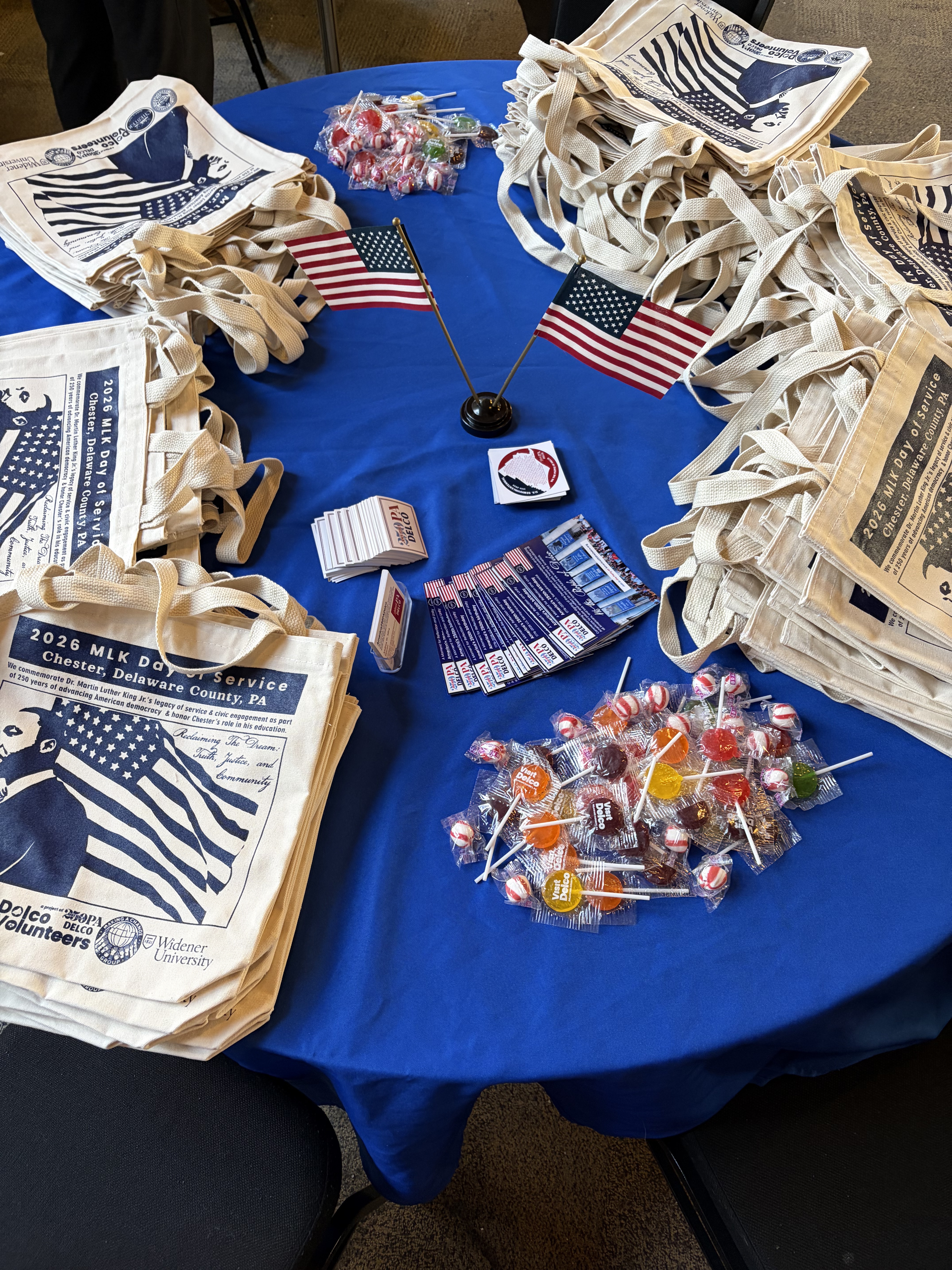 America250PADelco tote bags and lollipops displayed on a table