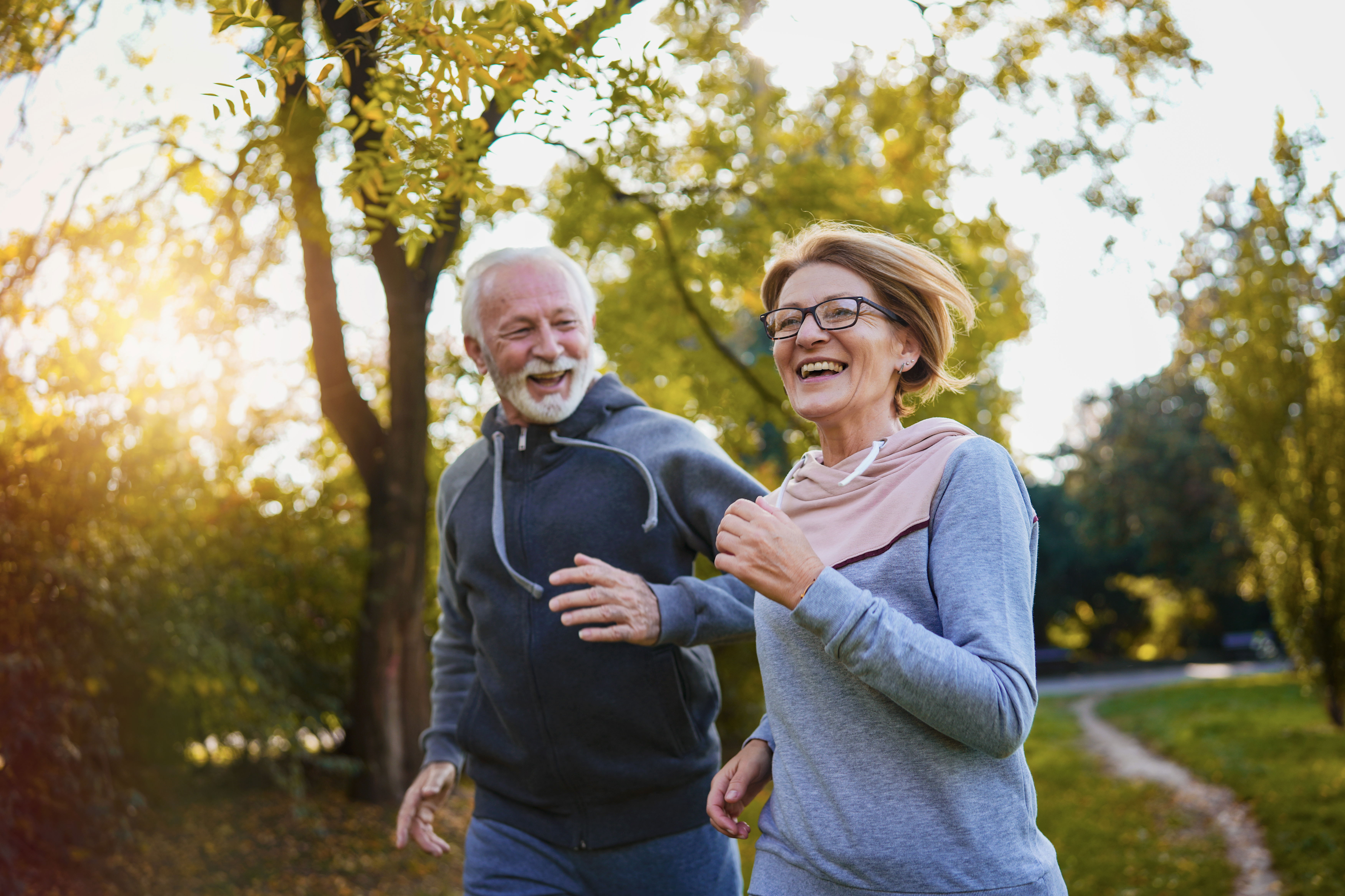 Male and female runners smiling as they run